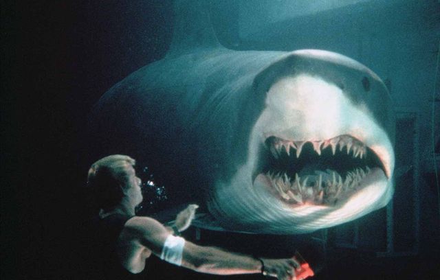 On est à la fin de la décennie 1990 (1999 très exactement), et « Peur Bleue », alias « Deep Blue Sea », nous offre un condensé du savoir-faire plus ou moins douteux de cette décennie en matière de film d’action. Une équipe de scientifiques/aventuriers veut trouver un remède face à la maladie d’Alzheimer en utilisant des requins, et tout part en vrille. Du grand n’importe quoi niveau faisabilité.