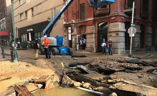 Le personnel du département des eaux de la ville de Philadelphie travaille après que la rupture des canalisations principales de la ville a entraîné une inondation mardi 3 juillet 2018.