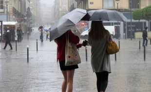 Image de deux femmes marchant sous la pluie.