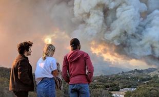 Kate, une jeune Californienne, regarde le Woolsey fire brûler, près de Los Angeles, depuis la route Mulholland Highway, le 9 novembre 2018.