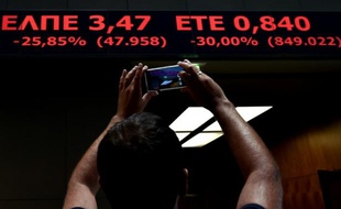 Un homme photographie les cours à la bourse d'Athènes le 3 août 2015