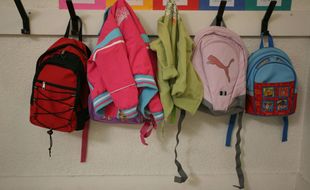 Premier jour de rentrée scolaire dans une école maternelle de Toulouse et petits sacs d'écolier suspendus a un porte-manteau (illustration).