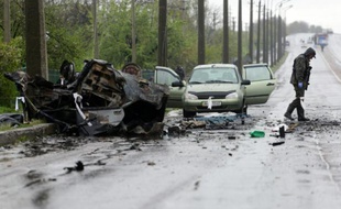 Un expert examine les lieux d'un bombardement qui a fait 4 morts, près d'un point de contrôle séparatiste d'Olenivka, dans l'est de l'Ukraine, le 27 avril 2016