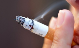 Une femme finit de fumer une cigarette (image d'illustration).
