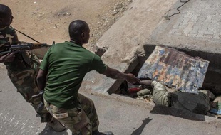 Un soldat nigérian découvre un cadavre en décomposition dans un égout dans la ville de Bama (nord du Nigéria), le 25 mars 2015