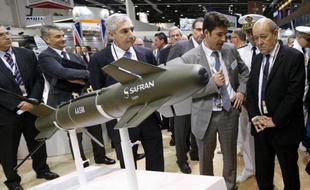 Le ministre de la Défense Jean-Yves Le Drian (d) de passage au stand Sagem du groupe Safran lors d'un salon international de la Défense à Abou Dhabi le 22 février 2015
