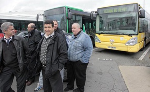 Des chauffeurs de bus de la compagnie des Courriers de l'Ile-de-France (CIF) se tiennent près de bus au siège d'une des entreprises de transport en commun de Villepinte, le 2 avril 2010.