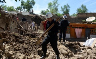 Des secouristes chinois fouillent les décombres d'une maison dévastée par un tremblement de terre le 23 juillet 2013 à Dingxi