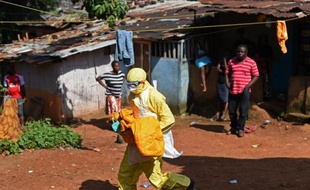 Le corps d'un enfant victime d'Ebola emporté pour son inhumation par un membre de la Croix Rouge, le 12 novembre 2014 à Freetown
