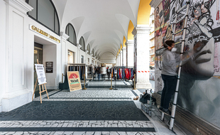 César Malfi en train de peindre sous les arcades pour les Galeries Lafayette Nice Masséna
