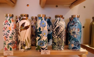 Des gourdes fleuries en inox de la marque italienne 24 Bottles, en rayon dans un magasin Altermundi à Paris 3
