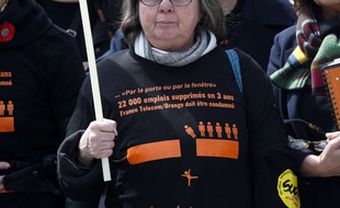 Une syndicaliste française portant un tee-shirt avec la mention : « 22 000 emplois supprimés en 3 ans. France Télécom doit être condamné » au début du procès du groupe français France Télécom, devant le tribunal de Paris, le lundi 6 mai 2019.