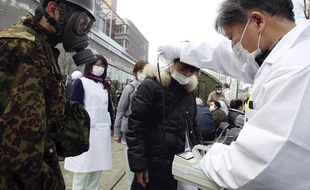 Un médecin mesure le degré d'exposition aux radiations grâce à un compteur Geiger, près de Fukushima le 13 mars 2011.