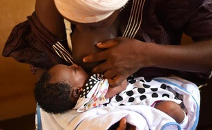 Une femme allaite son enfant en attendant une visite de routine chez le médecin au centre de santé de Kuntorloh dans la banlieue de Freetown (Sierra Leone) le 14 novembre 2014