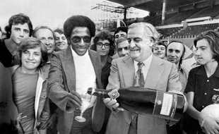 Paulo César sable le champagne après avoir signé un contrat à l'OM, avec le président du club Fernand Méric, le 11 juillet 1974.