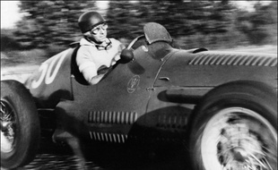 Photo datant de 1953 du coureur automobile argentin de Maserati Juan Manuel Fangio en course lors du Grand Prix Automobile sur le circuit de Monza (Italie).