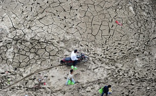 Des Indiens traversent la zone marécageuse de la rivière Yaumna après le retrait des eaux liée à une crue dans la région de Sangam à Allahabad le 13 septembre 2016.