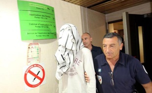 Un policier accompagne un jeune homme de 21 ans, prédicateur salafiste présumé, au tribunal de Saint-Denis à La Réunion, le 5 juin 2015