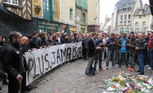 Le cortège composé de proches de la victime et d'agents de sécurité s'est recueilli devant le bar où s'est déroulé le drame.
