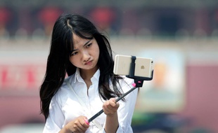 Une femme utilise une perche à selfies à Pékin en Chine, le 30 avril 2015.