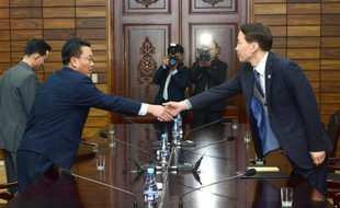 Kim Ki-Woong (d), haut responsable du ministère sud-coréen de l'Unification serre la main de son homologue nord-coréen, lors d'une rencontre à Panmunjom, le 26 novembre 2015 dans la zone démilitarisée entre les deux Corées