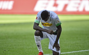 Marcus Thuram, l'attaquant de Moenchengladbach, met un genou à terre en hommage à George Floy après avoir marqué son deuxième but lors du match de Bundesliga entre le Borussia et l'Union Berlin dimanche 31 mai 2020. (AP Photo/Martin Meissner, Pool)/