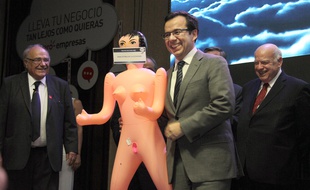 Hilare, le ministre de l'Economie Luis Felipe Céspedes reçoit son cadeau de Noël, de la part d'un syndicat de parons.