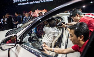 Des journalistes autour d'une Mercedes Benz E-Class le 24 avril 2015 au salon automobile de Pékin
