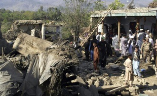Des policiers et habitants au milieu des ruines de maisons détruites par un puissant séisme, le 27 octobre 2015 à Lower Dir, au Pakistan