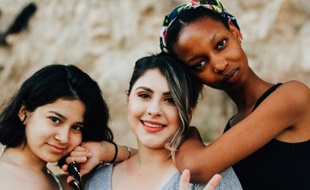 Trois femmes d'ethnies différentes posant ensemble