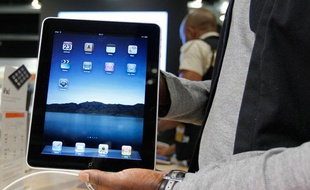 Un vendeur tient l'iPad d'Apple lors de son lancement à Bruxelles le 23 juillet 2010.