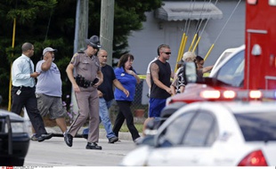 Un policier accompagne les parents venus récupérer leurs enfants après qu'une voiture a percuté une garderie en Floride, le 9 avril 2014.