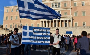 Des manifestants grecs brandissent un drapeau grec pour demander de changer l'Europe, le 29 juin 2015, en face du parlement, dans le centre d'Athènes