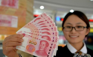 Une employée de banque montre les nouveaux billets de 100 yuan, le 12 novembre 2015 à Hadan, dans le nord de la Chine