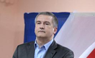 Le Premier ministre pro-russe de Crimée Serguiï Axionov sort de l'isoloir le 16 mars 2014 dans un bureau de vote à Simféropol