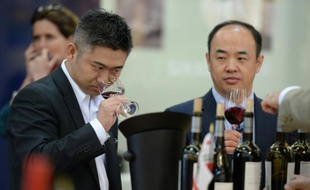 Des visiteurs goûtent un vin rouge lors du salon Vinexpo à Bordeaux, le 15 juin 2015