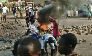 Des burundaises près d'une barricade en feu, à Bujumbura le 21 juillet 2015