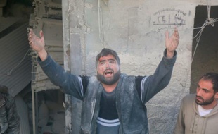 Un Syrien appelle à l'aide après un raid aérien contre une zone d'Alep détenue par les rebelles, le 11 mars 2016