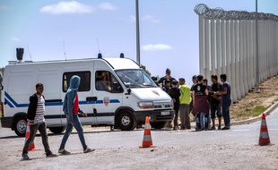 Des migrants et des policiers dans la Jungle de Calais, près de la rocade portuaire.