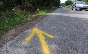 Une flèche jaune réalisé par les forces de l'ordre montrant le lieu exact de l'accident de voiture dans le Morbihan qui a coûté la vie à quatre adolescents.