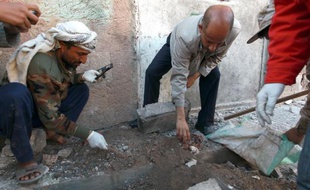 Des membres de l'organisation chiite Huthi rassemblent des indices, le 5 janvier 2015 après l'explosion de leur permanence à Sanaa