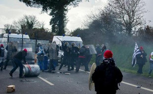 Des manifestants "bonnets rouges" affrontent la police à côté d'un portique d'écotaxe en Bretagne, le 15 février 2014