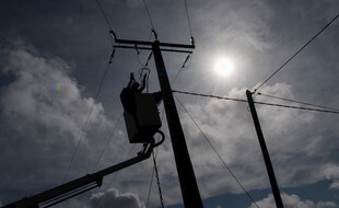 (Photo d'illustration) Un homme répare une ligne à haute tension.