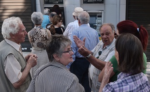 Le 30 juin 2015, à Athènes (Grèce), des retraités discutent politique tout en faisant la queue devant des distributeurs de billets.