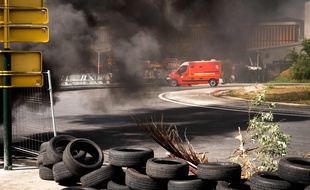 Un camion des pompiers devant une barricade aux Abymes, en Guadeloupe, le 17 novembre 2021. (Photo by Carla BERNHARDT / AFP)