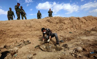 Un Iraquien inspecte les restes des corps de Yazidis tués par l'EI le 3 février 2015 au nord-ouest de l'Irak