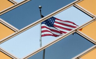 Le drapeau national américain se reflète sur les fenêtres du bâtiment de l'ambassade américaine à Kaboul le 30 juillet 2021.