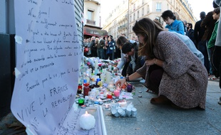Scènes de recueillement le 15 novembre 2015 à Paris après la série d'attentats qui a fait au moins 129 morts. Des anonymes déposent fleurs, bougies et dessins devant Le Carillon et le Petit Cambodge.