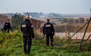 Des agents de sécurité inspectent la clôture endommagée par des migrants qui ont pénétré dans le tunnel sous la Manche à Coquelles, dans le Pas-de-Calais, le 3 octobre 2015