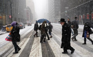 Des piétons traversent une rue de New York pris dans la tempête de neige, le 26 janvier 2015